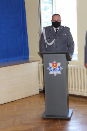 Komendant Powiatowy Policji w Łasku przy mównicy gratuluje awansowanym i dziękuje wszystkim za przybycie na uroczystości.