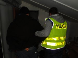 Konwojowanie zatrzymanego przez policjanta.