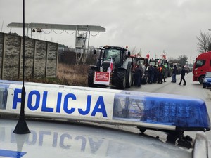 Kolumna ciągników rolniczych ustawiona wzdłuż ulicy kolejowej w Łasku.