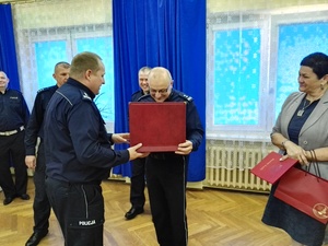 Komendant Powiatowy Policji w Łasku wręcza upominek w podziękowaniu za współpracę.