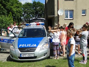 Dzieci oglądają policyjny radiowóz.
