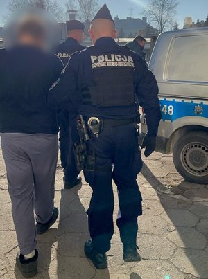 policjanci prowadzą zatrzymanego