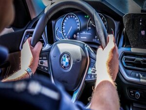 Policjant trzyma kierownicę radiowozu grupy speed, marki BMW.