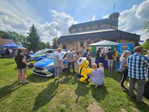 Policjanci na stoisku prezentują elementy policyjnego wyposażenia. Wokół policyjnego namiotu znadują się osoby, które rozmawiają.