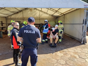 Policjant pomaga przy segregacji poszkodowanych.