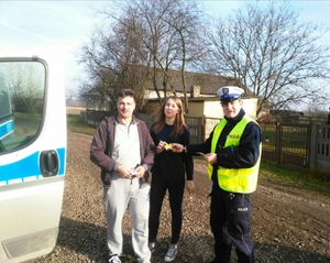 Policjant rozdaje odblaski.