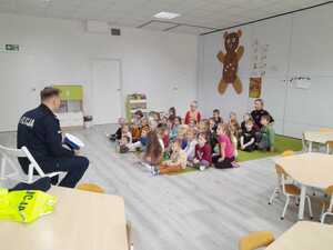 Policjant opowiada dzieciom o pracy policjanta ruchu drogowego.