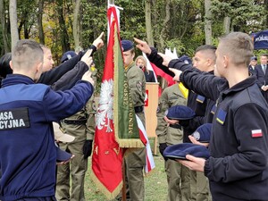 Uczniowie klas mundurowych stoją przy sztandaże szkoły i ślubują.