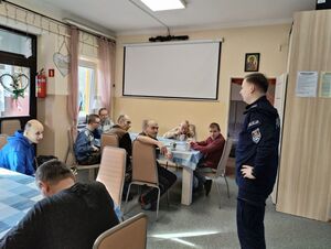 Policjant rozmawia z podopiecznymi fundacji o bezpieczeństwie.