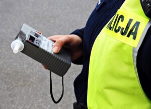 Policjant trzyma w dłoni urządzenie do badania stanu trzeźwości,