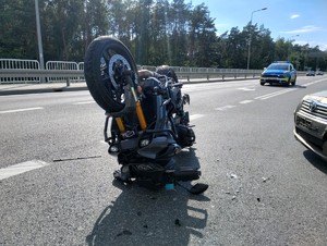 Wywrócony motocykl, w tle widać policyjny radiowóz.