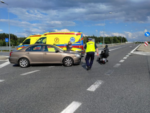 Policjant wykonuje czynności na miejscu zdarzenia drogowego.