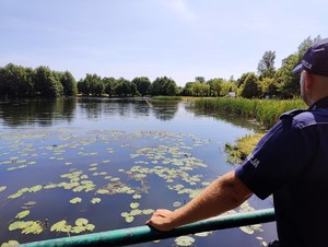 Policjant obserwuje kąpielisko miejskie.