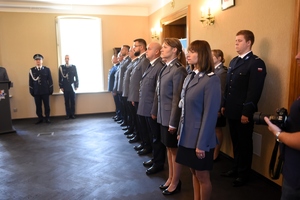 Mianowani policjanci w mundurach galowych stoją w szeregu.