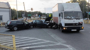 Miejsce zdarzenia drogowego. Na drodze stoją uszkodzone pojazdy.