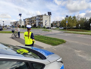 Policjantka z Wydziału Ruchu Drogowego, sprawdza oznakowanie w rejonie szkoły.