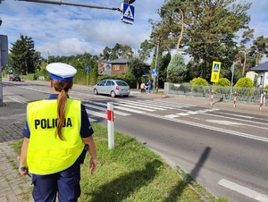 Policjantka z Wydziału Ruchu Drogowego, sprawdza oznakowanie w rejonie szkoły.