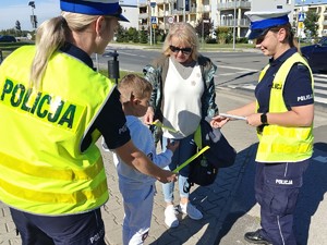 Policjantki rozdają odblaski przechodnią.