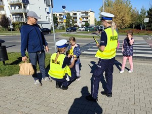 Policjantki rozdają odblaski przechodnią.