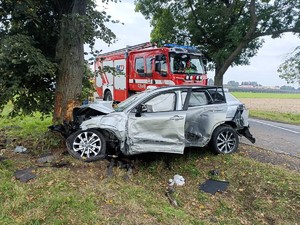 Uszkodzony samochód marki toyota, w tle widać wóż strażacki.