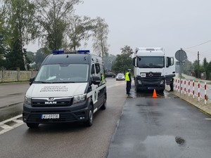 Policjanci kontrolują pojazd ciężarowy.