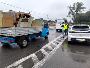 Funkcjonariusze Wojewódzkiego Inspektoratu Ochrony Środowiska kontrolują pojazd przewożący odpady.