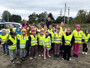 Grupowe zdjęcie dzieci z policjantem.