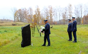 Zastępca komendanta składa kwiaty pod pamiątkową tablicą.