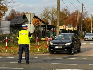 Policjant stoi na środku skrzyżowania i kieruje ruchem