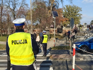 Policjanci kierują ruchem na przejściu dla pieszych.