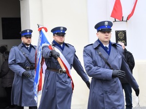 Poczet sztandarowy składający się z policjantów wychodzi z kościoła.