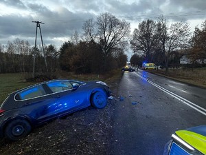 Miejsce zdarzenia drogowego. Na poboczu drogi w rowie stoi uszkodzony samochód.