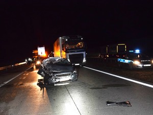 Miejsce zdarzenia drogowego. Na pierwszym planie widać uszkodzony pojazd marki Volvo.  W tle stojące pojazdy oraz policyjny radiowóz.