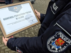 Policjant trzyma w rękach akt uznania o treści &amp;amp;quot;W podziękowaniu za osiągnięcie w 2024 roku najlepszych wyników w pionie kryminalnym.