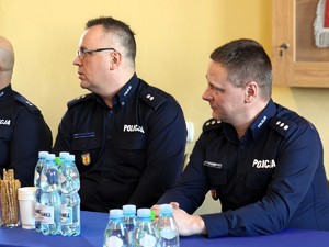 Przy stole siedzi dwóch policjantów.