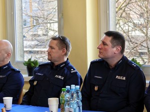 Przy stole siedzi dwóch policjantów.