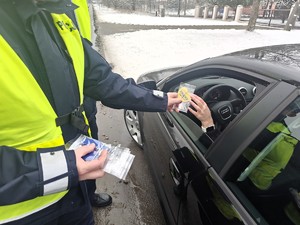 Policjant wręcza kierującej zawieszkę zapachową.