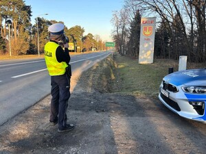 Policjantka mierzy prędkość pojazdów.