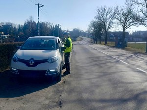 Policjantka stoi przy kontrolowanym pojeździe.