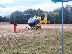 Śmikłowiec Lotniczego Pogotowia Ratunkowego stoi na polu.