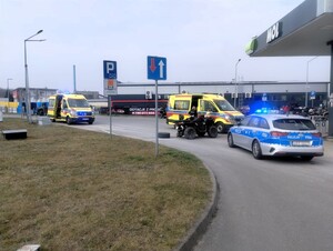 Miejsce zdarzenia. Na drodze stoi uszkodzony quad, policyjny radiowóz i samochody zespołów ratownictwa medycznego.