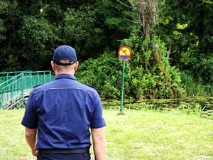 Policjant sprawdza prawidłowe oznakowanie kąpieliska.