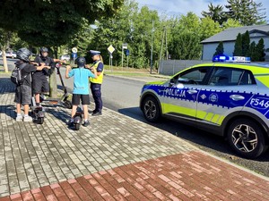 Policjanci kontrolują kierujących hulajnogami.