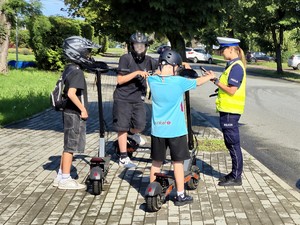 Policjanci kontrolują kierujących hulajnogami.