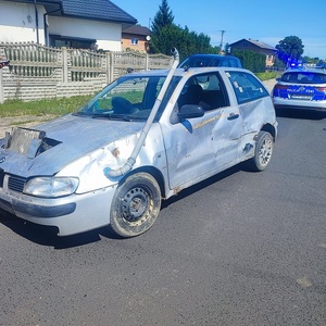 pojazd koloru szarego z uszkodzeniami blacharskimi. W oddali rodiowóz policyjny.