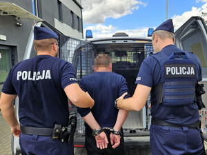 Policjanci trzymają poszukiwanego.