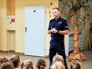 Policjant rozmawia z dziećmi.