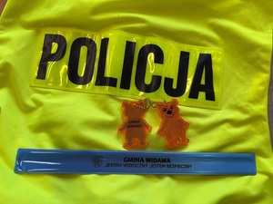kamizelka odblaskowa. na niej odblaskowy miś i opaska w kolorze niebieskim.