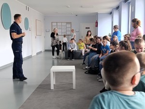 Policjant rozmawia z uczniami o bezpieczeństwie.