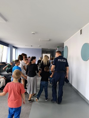 Policjant rozmawia z uczniami o bezpieczeństwie.